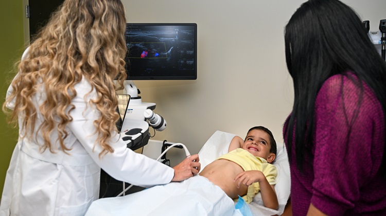 Dr. Felipez performing intestinal ultrasound on young boy patient.